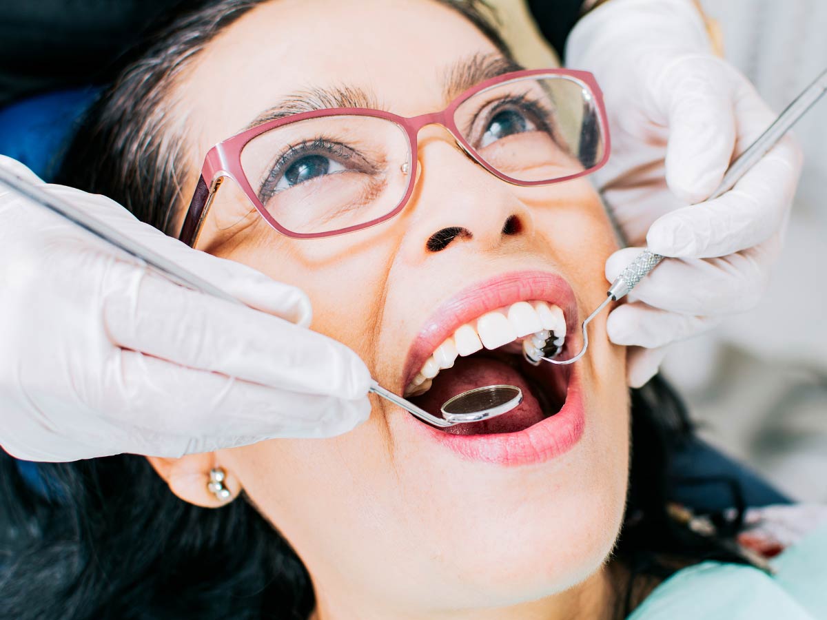 Dentist performing filling to treat tooth decay without extraction